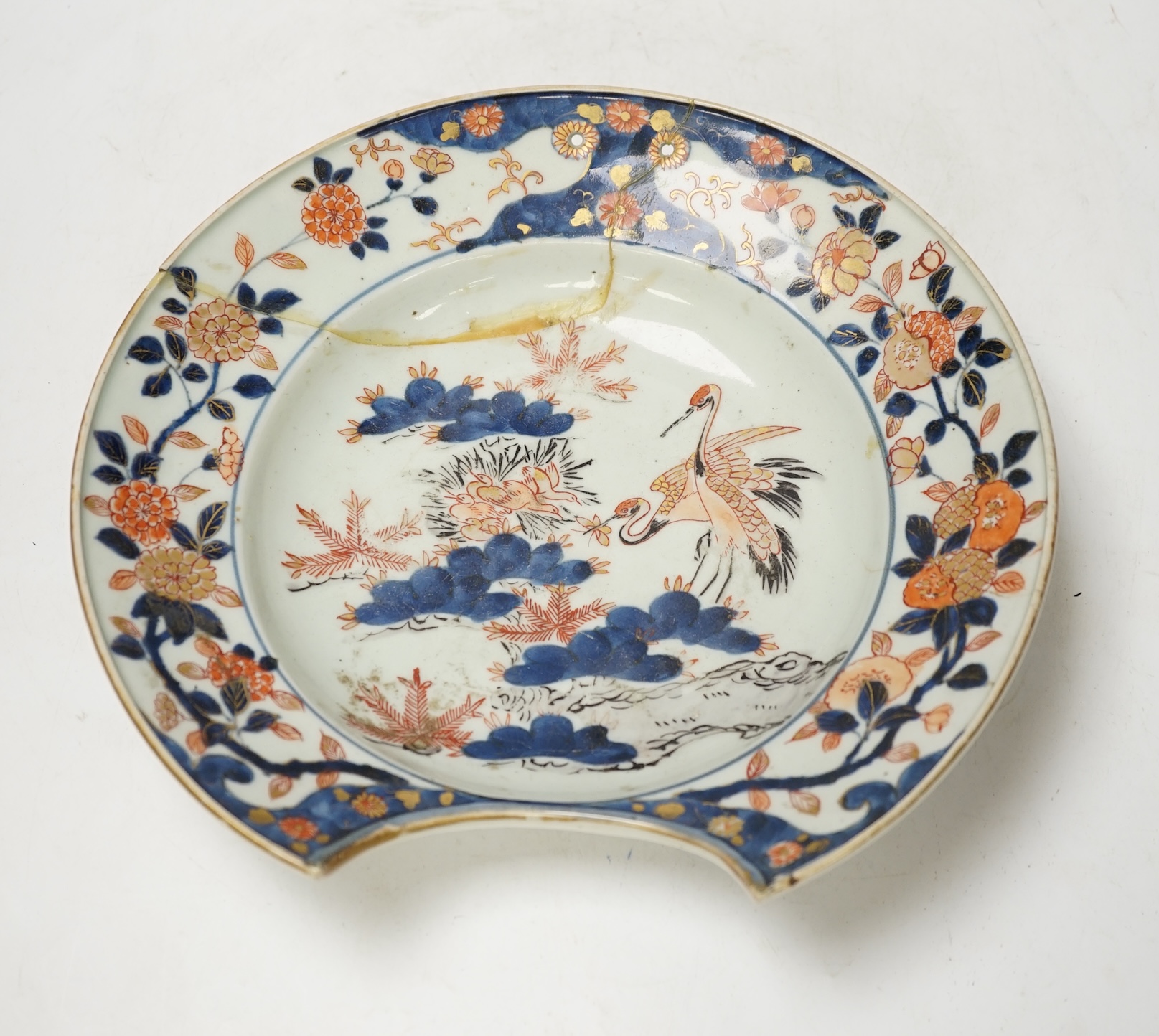 A Japanese Arita ‘cranes and chicks’ barber's bowl, early 18th century, in Imari palette, 27.5cm diameter. Condition - poor (a.f.)